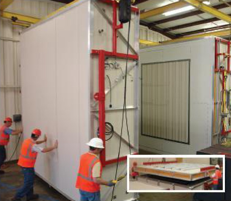 Construction crew testing insulated wall panel assembly inside a structural performance lab.